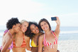 Four friends posing for a photo on the beach