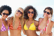 Photo: Four friends smiling while wearing sunglasses Four friends smiling while wearing sunglasses