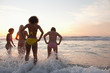Four women wading through the waves