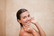 Side view of smiling woman taking a shower
