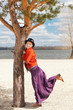 Happy Woman standing by the tree on a coast
