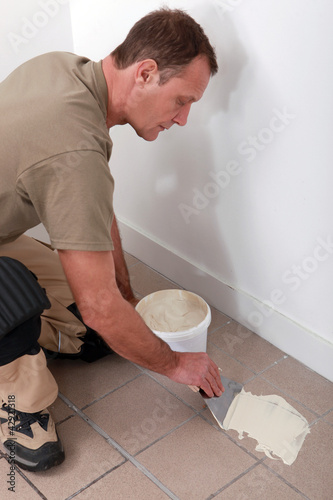 Foto: Man preparing to retile a floor Man preparing to retile a floor