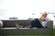 Foto: Senior woman sitting on outdoor sofa Senior woman sitting on outdoor sofa