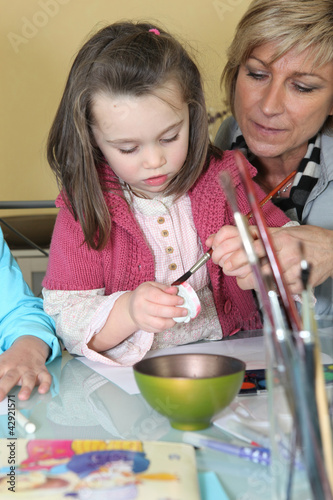 Foto: Little girl painting a figurine Little girl painting a figurine