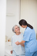 Nurse helping a smiling senior patient