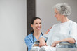 Smiling nurse looking at a senior patient in a wheelchair