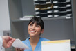 Smiling nurse behind a desk giving a file to a doctor