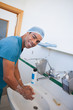 Happy male surgeon washing his hands