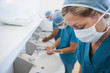 Female surgeon in a hospital washoom washing her hands