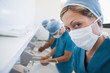 Female surgeon in a hospital washroom washing her hands with a mask 