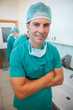 Smiling surgeon with his arms folded