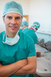 Smiling surgeon with his arms crossed