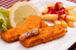 Panierte Fischstäbchen mit Zitrone und grünem Salat