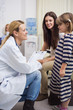 Doctor squatting while talking to girl in a waiting room