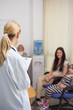 Blonde doctor talking to patient in a waiting room