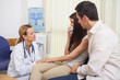 Female doctor talking to woman in a waiting room