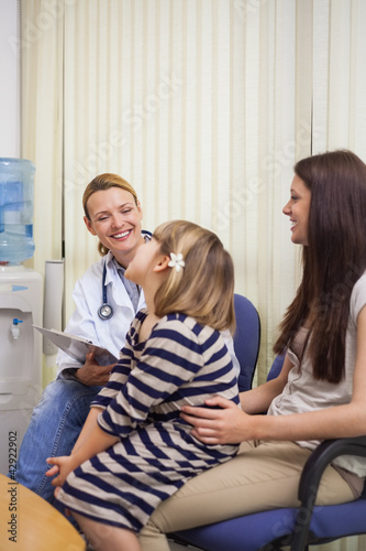 Photo: Smiling doctor and girl sitting in a waiting room Smiling doctor and girl sitting in a waiting room