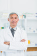 Pharmacist with his arms crossed standing in a pharmacy