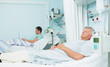 Two male patients lying on hospital beds