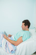 Patient touching a tactile tablet while lying on a bed