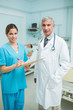 Nurse and doctor looking at files in a hospital with two patients