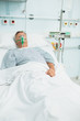 Conscious senior male patient lying on a bed with an oxygen mask