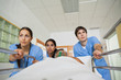 Medical team wheeling the bed of a patient in a hallway