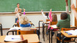 Back view of elementary students raising hands