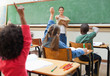 Back view of primary students raising hands