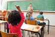 Back view of girl raising hand during class