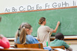 Photo : Teacher writing on board Teacher writing on board