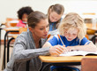 Helpful teacher next to a student