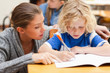 Helpful teacher assisting one of her students