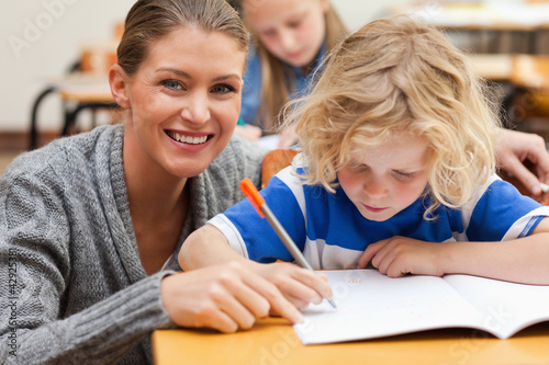 Photo: Smiling teacher helping one of her students Smiling teacher helping one of her students
