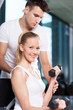 Woman Lifting Weights with Personal Trainer