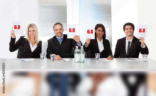 Photo: Panel judges holding perfect score signs Panel judges holding perfect score signs