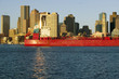 Photo: Bright red cargo ship travels in front of Boston Harbor and the Boston skyline at sunrise as seen from South Boston, Massachusetts, New England Bright red cargo ship travels in front of Boston Harbor and the Boston skyline at sunrise as seen from South Boston, Massachusetts, New England