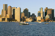 Photo: Boat travels in front of Boston Harbor and the Boston skyline at sunrise as seen from South Boston, Massachusetts, New England Boat travels in front of Boston Harbor and the Boston skyline at sunrise as seen from South Boston, Massachusetts, New England