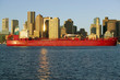 Photo: Bright red cargo ship travels in front of Boston Harbor and the Boston skyline at sunrise as seen from South Boston, Massachusetts, New England Bright red cargo ship travels in front of Boston Harbor and the Boston skyline at sunrise as seen from South Boston, Massachusetts, New England