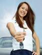Foto: Pretty woman proudly presents the key of her car outdoors Pretty woman proudly presents the key of her car outdoors