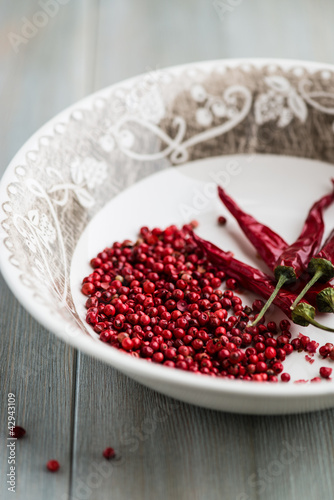 Photo: Pink peppercorns and dried chili peppers in a bowl Pink peppercorns and dried chili peppers in a bowl