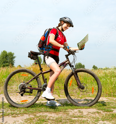 Photo: Happy Young Woman riding bicycle outside. Healthy Lifestyle Happy Young Woman riding bicycle outside. Healthy Lifestyle