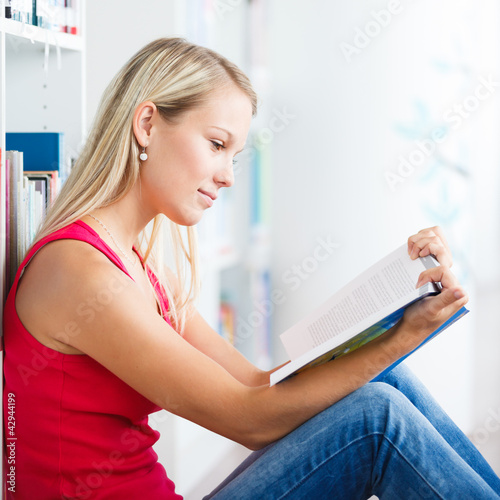 Foto: in the library - pretty female student with books in the library - pretty female student with books