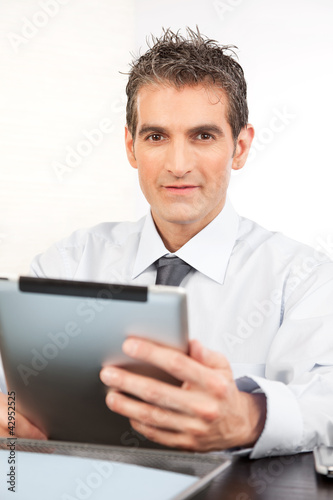 Photo: Businessman Holding Digital Tablet Businessman Holding Digital Tablet