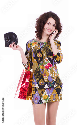 Foto: Young woman with shopping bags talking on cell phone Young woman with shopping bags talking on cell phone