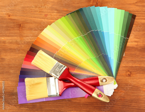 Foto: paint brushes and bright palette of colors on wooden background paint brushes and bright palette of colors on wooden background