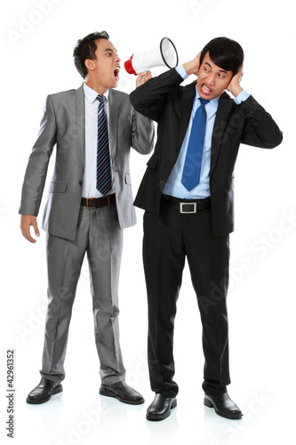 Photo: boss shouting over his employee's ear boss shouting over his employee's ear