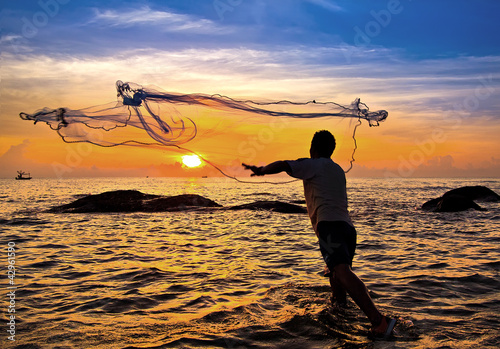 Photo: throwing fishing net during sunset , thai throwing fishing net during sunset , thai
