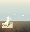 Paper cut of child on wood table