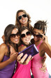 Four girls  taking pictures of themselves through cell phone